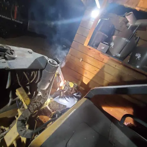 This image shows a welder working on a large piece of equipment.